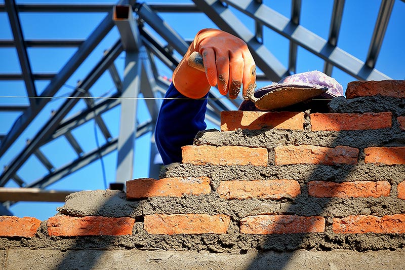 Un couvreur maçon en train de réaliser un mur en brique